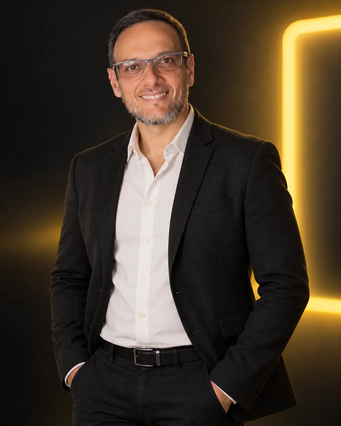 Fábio Pantoja, criador da Letreiro Digital, de terno escuro, sorrindo, diante de um letreiro de luz amarela