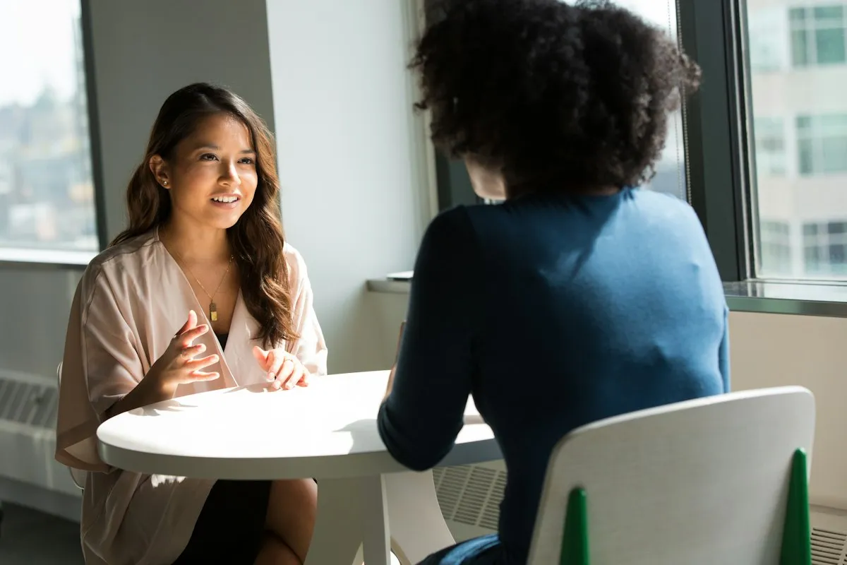 Duas mulheres conversando à mesa, com calma